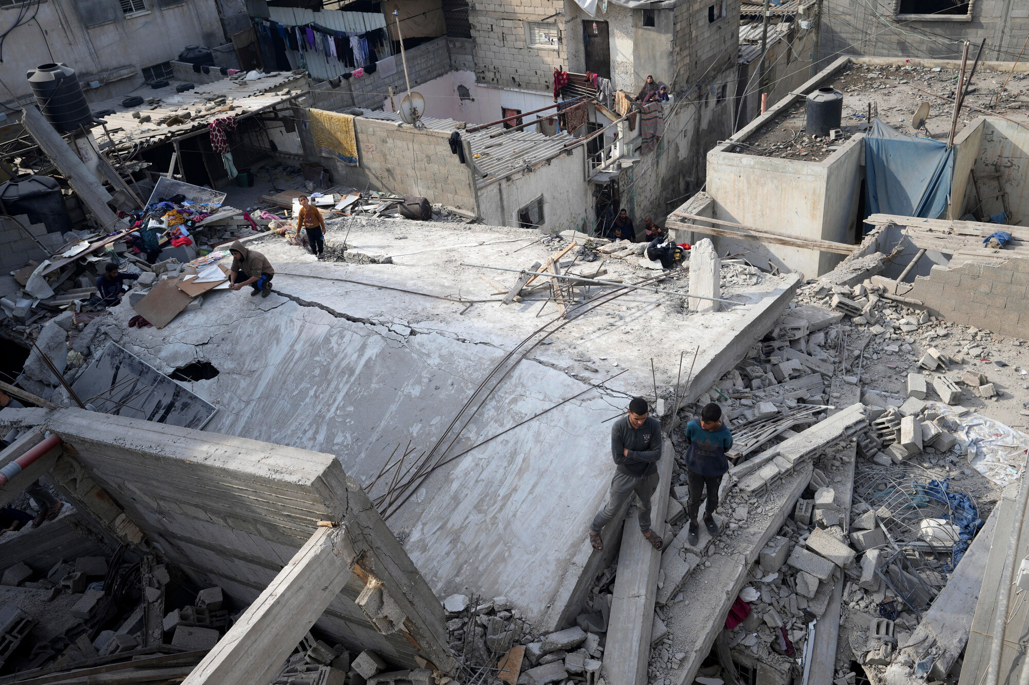 Palestinians search for the bodies of the Al-Hor family killed in the Israeli bombardment of the Gaza Strip in Nusseirat refugee camp, central Gaza Strip, early Friday, Dec. 8, 2023.