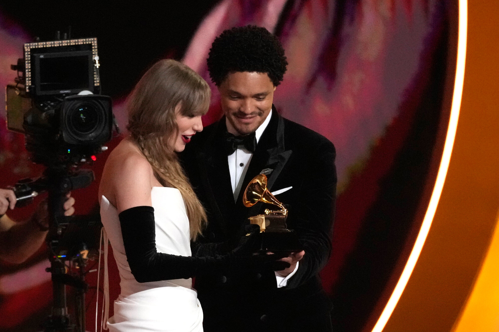 Host Trevor Noah, right, presents Taylor Swift with the award for best pop vocal album for "Midnights" during the 66th annual Grammy Awards on Sunday, Feb. 4, 2024, in Los Angeles.