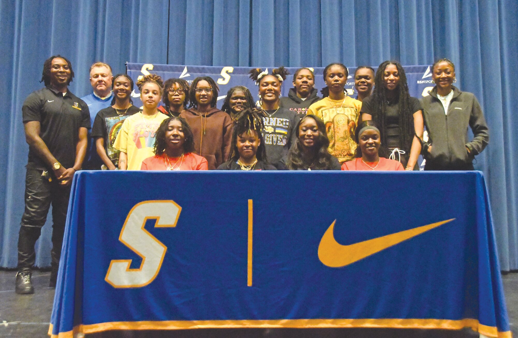 Sumter High seniors, seated from left, Rickell Brown, Keziyah Sanders, Dalashia Brunson and Kiara Croskey are surrounded by teammates after signing to continue their basketball careers on Friday.