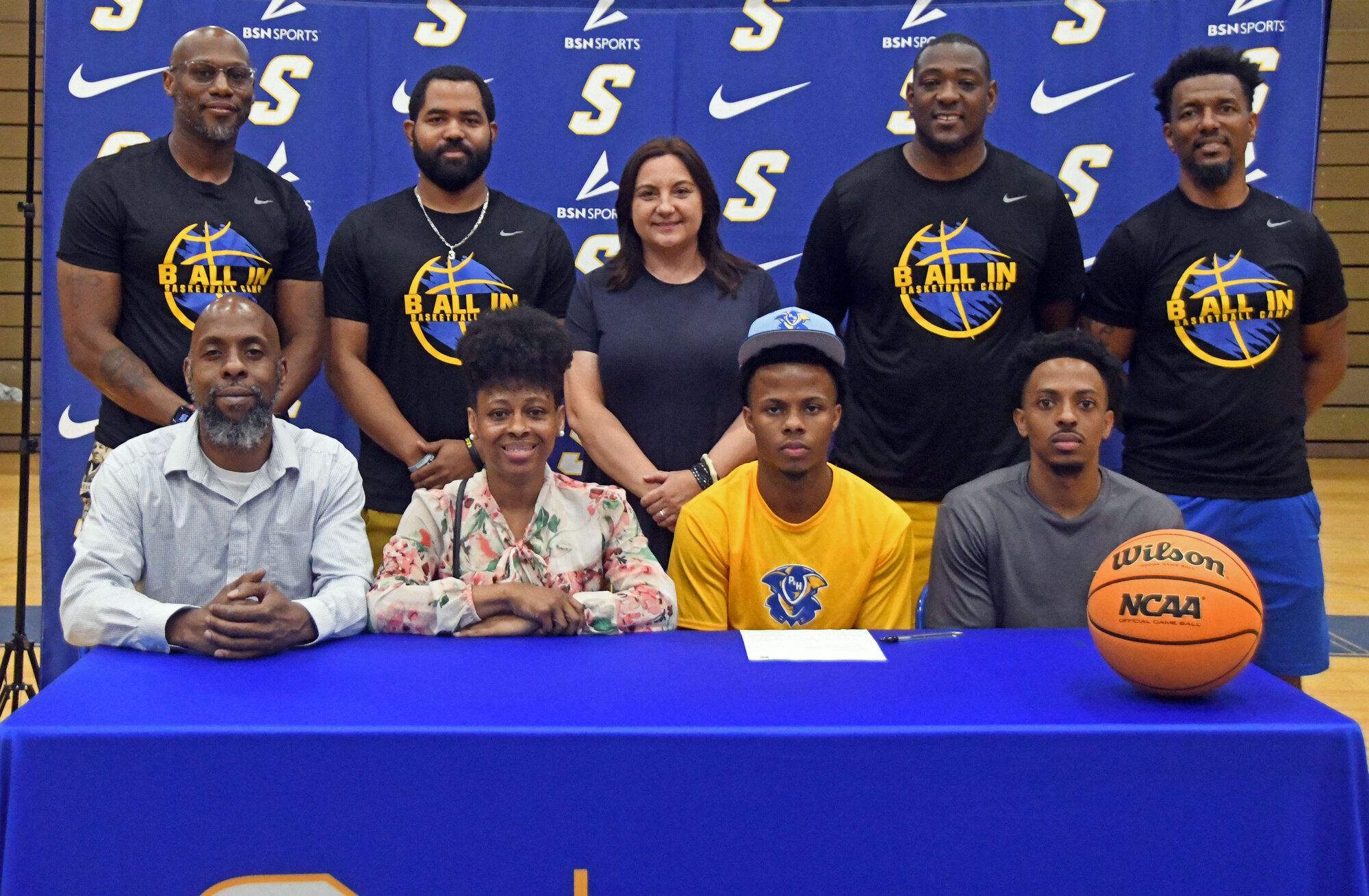 Sumter High's Caleb Jenkins, seated center right, is surrounded by family, coaches and administrators after signing to continue his basketball career at Patrick and Henry on Thursday.